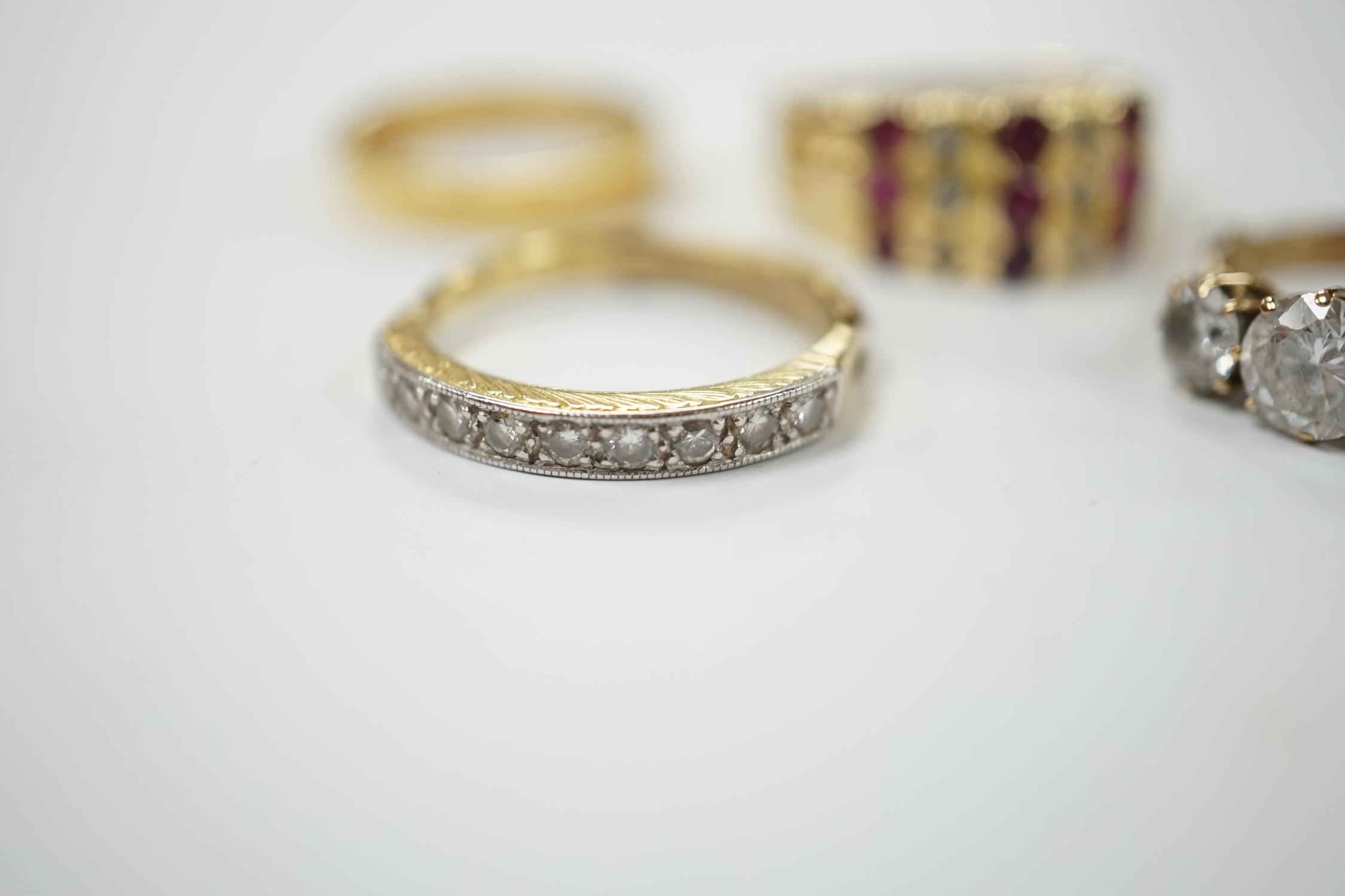 An 18ct and diamond chip set half hoop ring, size L/M, an 18ct gold band and two 9ct and gem set rings. Condition - fair